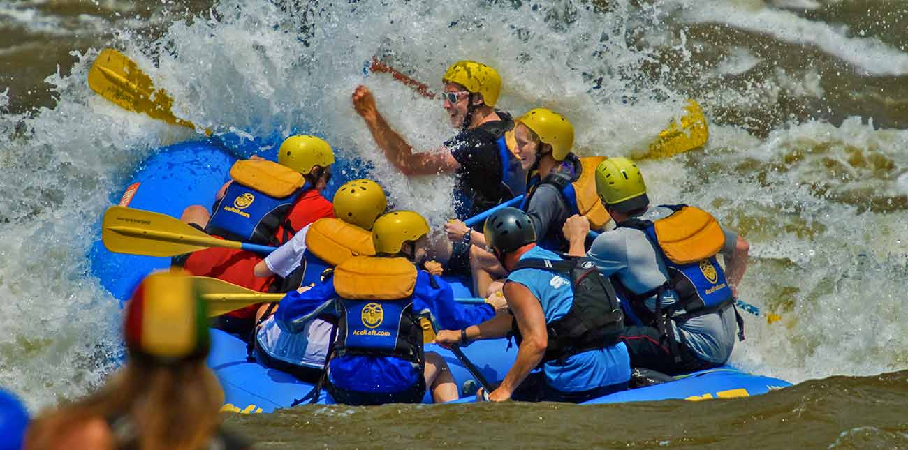 An ACE Adventure Resort raft hits a huge wave on the new river gorge during a spring rafting trip.