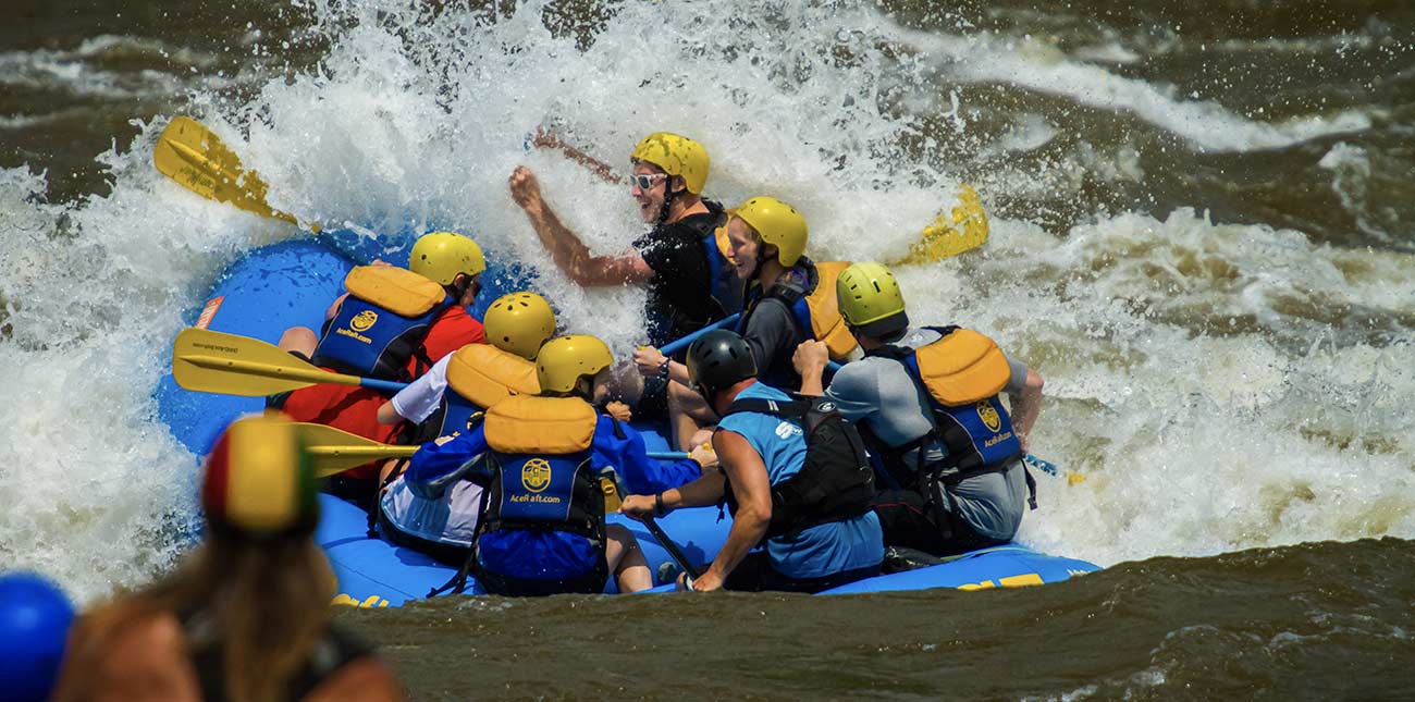 Rafters on the Lower New River plow through a big whitewater wave.