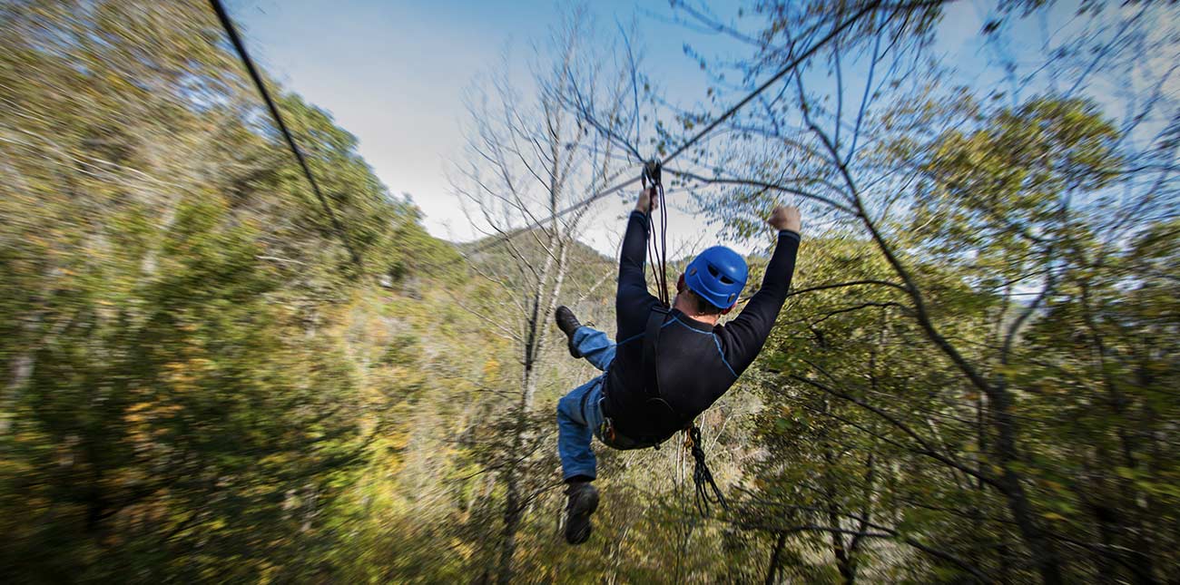 A canopy zip line tour flying through the trees at ACE Adventure Resort in West Virginia.