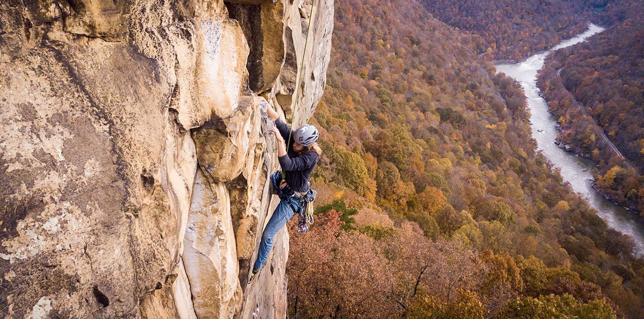 Using top rope to climb the hard sandstone walls of the New River Gorge in West Virginia.