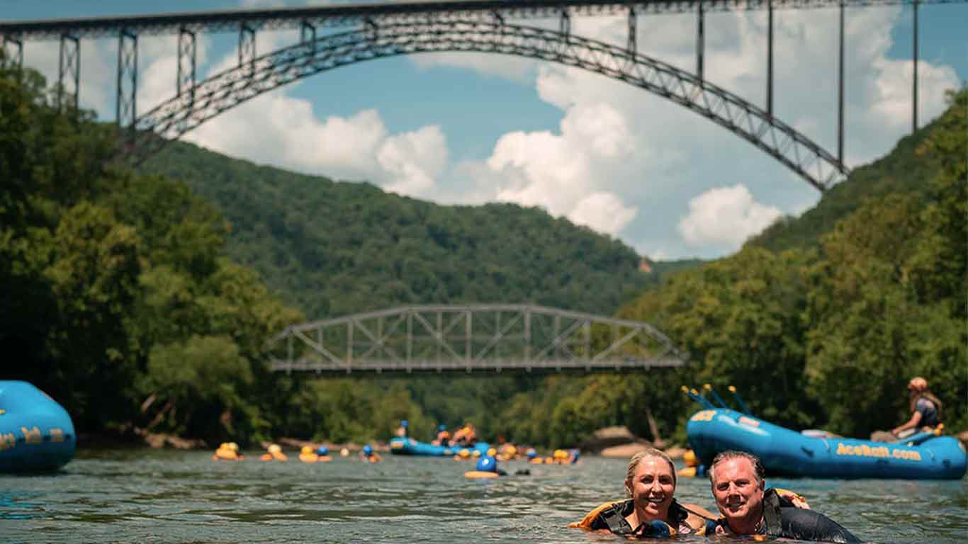 Couple posing in the New River under the New River Gorge Bridge