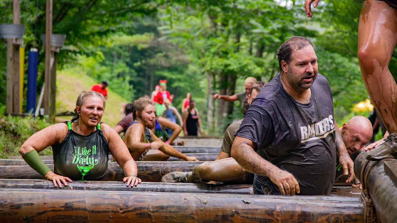 Racers on the obstacles on the mud run